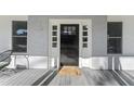 Close-up of the front door with sidelights and a welcome mat on a covered porch at 123 E Weatherspoon St, Sanford, NC 27330