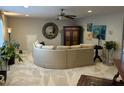Spacious living room with a curved sofa, decorative mirror, and ample natural light at 12409 Angel Vale Pl, Durham, NC 27703