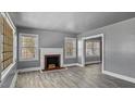 Cozy living room featuring a decorative fireplace, neutral paint, and abundant natural light at 1721 Raleigh Rd, Henderson, NC 27536