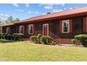 A cozy porch welcomes you to this single-story home with its painted siding and red metal roof at 1796 Steel Bridge Rd, Sanford, NC 27330