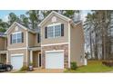Townhouse with neutral siding, stone accents, a single-car garage and well maintained lawn at 1802 Brim Dr, Haw River, NC 27258