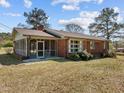 Classic brick ranch home with screened porch, mature landscaping, and inviting curb appeal at 2125 W Academy St, Holly Springs, NC 27540