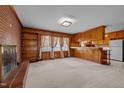 Warm living room featuring a brick fireplace, wooden paneled walls and built-in shelves at 2125 W Academy St, Holly Springs, NC 27540