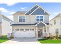 Charming two-story home featuring a two-car garage, and a welcoming front porch with a rocking chair at 2177 Campbell, Burlington, NC 27215