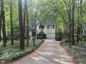 View of the home, showing the driveway and surrounding trees at 27 Creeks Edge Ct, Durham, NC 27713