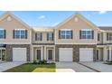 Townhome exterior with stone accents, individual garages, and manicured lawns showcases modern curb appeal at 2838 Egert Dr, Haw River, NC 27258
