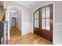 Elegant foyer with hardwood floors, wood trim, and frosted glass doors at 3 Alumwood Pl, Durham, NC 27705