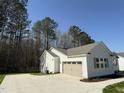 Side view of a single-story home featuring an attached garage and a concrete driveway at 325 Magnolia Run Way, Benson, NC 27504