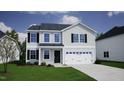 Inviting two-story home featuring a clean white garage door and complementary shutters under a partly cloudy blue sky at 35 Calabria Ct, Franklinton, NC 27525