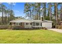 Beautiful single-story home with brick accents, a manicured lawn and attached garage at 3910 Hillgrand Dr, Durham, NC 27705