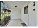 Charming front porch featuring hanging flower baskets, a white door and concrete floor at 3910 Hillgrand Dr, Durham, NC 27705