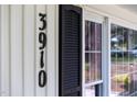 Close-up of the house number 3910 on the exterior wall next to a window with black shutters at 3910 Hillgrand Dr, Durham, NC 27705