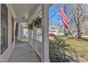 Inviting front porch featuring white columns and rails, decorated with hanging plants at 401 Newquay Ln, Wake Forest, NC 27587