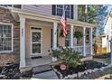 Close up of the front porch featuring plants, columns, and an American flag at 401 Newquay Ln, Wake Forest, NC 27587