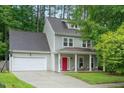 Charming two-story home with a red front door, attached garage and a well-manicured lawn at 4070 Landover Ln, Raleigh, NC 27616
