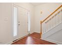 Inviting foyer with hardwood floors, a staircase, a white door, and a sidelight window at 4070 Landover Ln, Raleigh, NC 27616