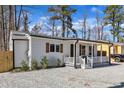 Side view of cozy house with white siding, wooden shutters, and a charming covered porch at 43 Nordan St, Angier, NC 27501