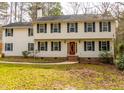 Traditional two-story home with a vibrant red front door and neatly kept lawn and mature landscaping at 4324 Old Lewis Farm Rd, Raleigh, NC 27604