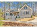 Charming two-story home with a welcoming front porch and well-manicured landscaping nestled in a beautiful wooded area at 4721 Cypress Ford Dr, Fuquay Varina, NC 27526