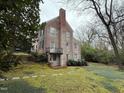 Exterior view of a brick house featuring a chimney, balcony, and backyard at 501 North St, Chapel Hill, NC 27514
