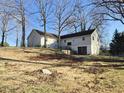 Spacious backyard with mature trees and a two-story home providing ample outdoor space and privacy at 512 Monroe Holt Rd, Graham, NC 27253