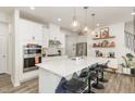 Modern kitchen with stainless steel appliances, white cabinetry, and a large island with pendant lighting at 609 Rawls Dr, Raleigh, NC 27610