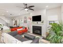 Open concept living room with a cozy fireplace, ceiling fan, and an abundance of natural light at 609 Rawls Dr, Raleigh, NC 27610