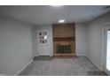 Cozy basement featuring brick fireplace and neutral carpet at 6600 Coach Light Cir, Raleigh, NC 27613