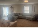 Cozy living room featuring a large sectional sofa, carpet, and natural light from sliding glass door at 700 Cider Mill Way, Zebulon, NC 27597