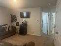 Comfortable living room with a television, dark sofa, and access to two hallways with white doors at 700 Cider Mill Way, Zebulon, NC 27597