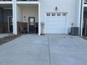 Driveway view of home featuring a garage and a welcoming front porch with seating at 829 S Franklin St, Wake Forest, NC 27587