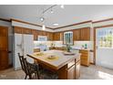 Well-lit kitchen features wood cabinets, white appliances, and a functional island at 8429 Bells Lake Rd, Apex, NC 27539