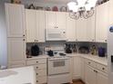 Bright kitchen with white cabinetry, white appliances, and a functional layout at 903 Teague Pl, Durham, NC 27707