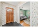 Welcoming foyer with floral wallpaper and a view into the living room, featuring hardwood floors at 914 S Crescent Dr, Smithfield, NC 27577