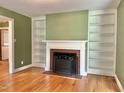 Cozy living room featuring a fireplace with built-in bookshelves and hardwood floors at 914 S Crescent Dr, Smithfield, NC 27577