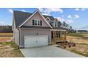 Charming home with gray siding, covered porch and a white garage door enhancing its curb appeal at 9353 Turkey Way, Middlesex, NC 27557