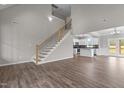 Open-concept living space with a staircase, hardwood floors, seamlessly connecting living, dining, and kitchen areas at 9353 Turkey Way, Middlesex, NC 27557