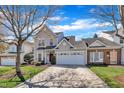 Two-story home with gray siding, brick accents, a two-car garage, and a well-manicured lawn at 10707 Edmundson Ave, Raleigh, NC 27614