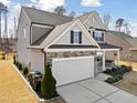 Gray two-story home with a manicured lawn, a two-car garage, and a covered front porch swing at 115 Cliffview Dr, Garner, NC 27529