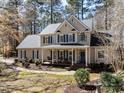 Inviting two-story home with blue shutters and a spacious front porch nestled among trees at 11619 John Allen Road Rd, Raleigh, NC 27614