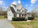 Charming two-story home with a front porch, attached garage, and a well-maintained lawn at 1210 Poplar Forest Lane Ln, Pittsboro, NC 27312