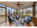 Cozy screened porch with wood floors, wicker seating, ceiling fan, and views of the backyard at 1210 Poplar Forest Lane Ln, Pittsboro, NC 27312