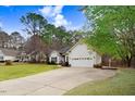Inviting single-story home with a well-maintained lawn, long driveway, and attached two-car garage at 129 Bennett Pl, Clayton, NC 27527