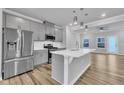 Modern kitchen featuring stainless steel appliances, gray cabinets, a center island, and seamless open-concept design at 1434 Rosepine Dr, Cary, NC 27519