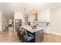 Modern kitchen features a spacious island with bar stools, stainless steel appliances, and pendant lighting at 197 S Clearbook Ct, Angier, NC 27501