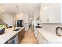 Bright, open kitchen with large island, white cabinetry, stainless appliances, and stylish light fixtures at 197 S Clearbook Ct, Angier, NC 27501