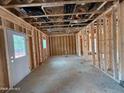 Unfinished interior space featuring exposed framing, a door to the backyard, and rough concrete flooring at 200 Dove Rd, Cameron, NC 28326