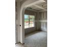 Living room featuring an archway and a large window overlooking the yard and unfinished walls at 200 Dove Rd, Cameron, NC 28326