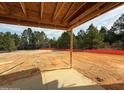 Unfinished backyard patio with trees in the background and exposed wood framing under a cloudy blue sky at 200 Dove Rd, Cameron, NC 28326