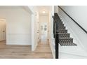 Bright foyer showing stairway and hallway with light wood flooring and fresh, neutral paint throughout at 244 Victor Ct, Garner, NC 27529